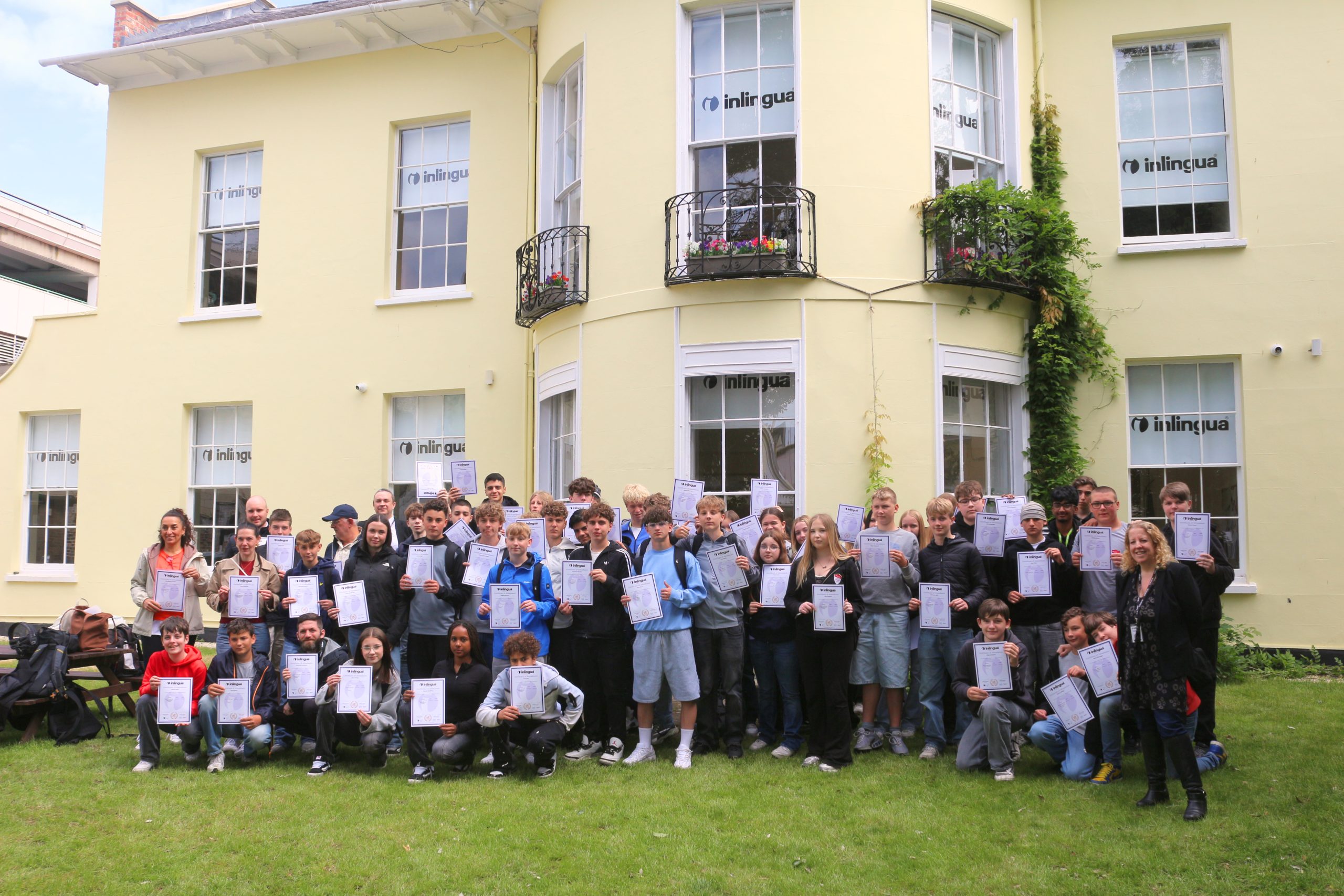 A large group of international junior students and inlingua Cheltenham staff together outside the school