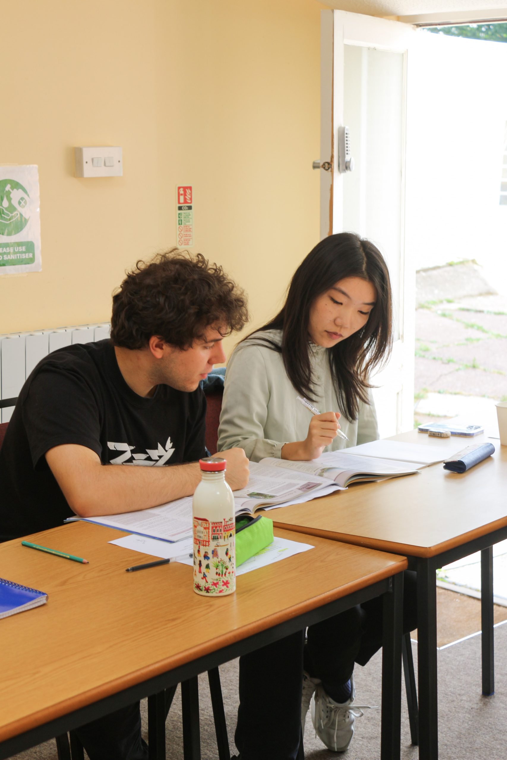 A teacher giving one-to-one feedback on a student's written work at inlingua Cheltenham