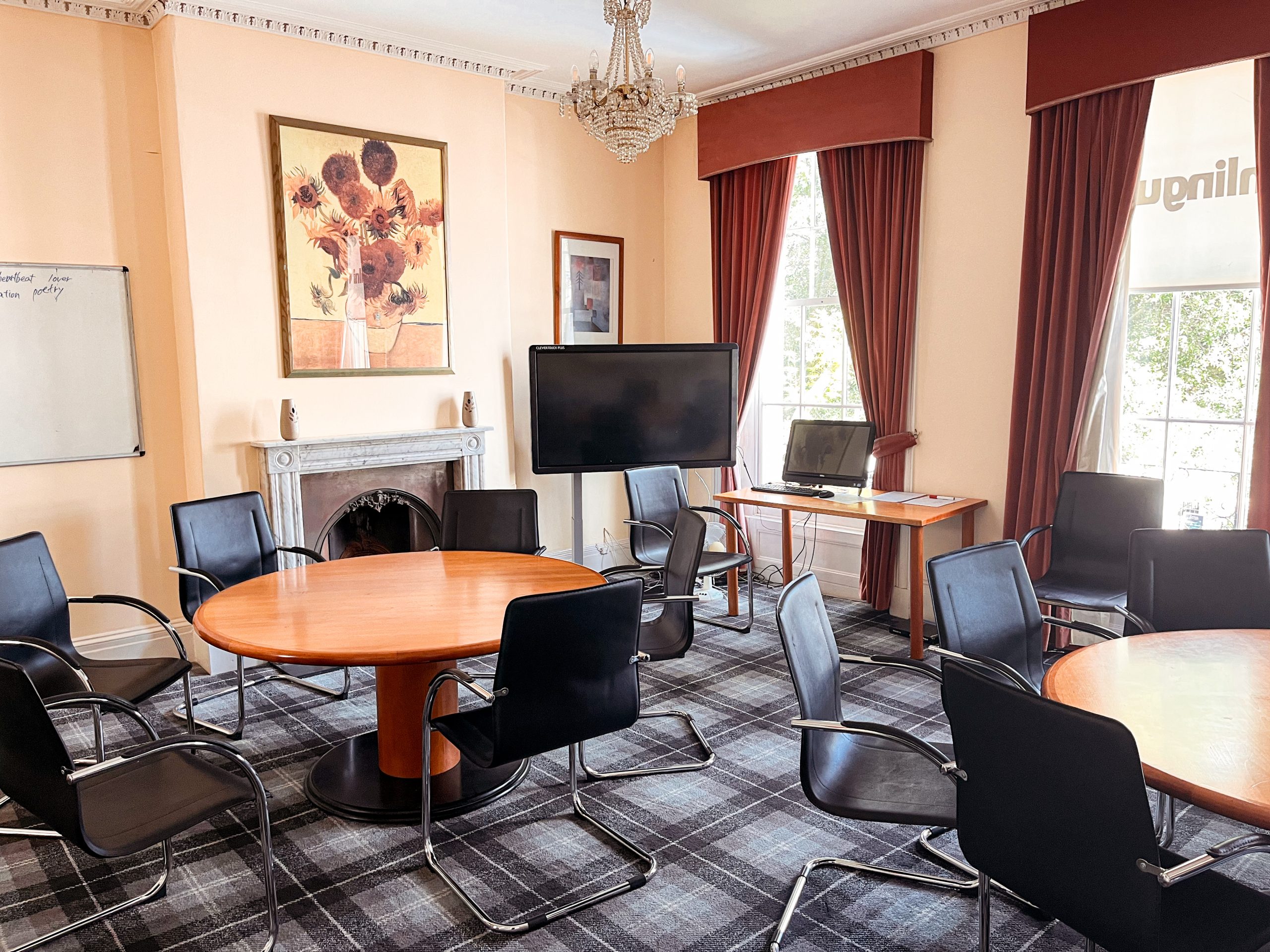 A bright classroom at inlingua Cheltenham with a large sash window and an interactive whiteboard