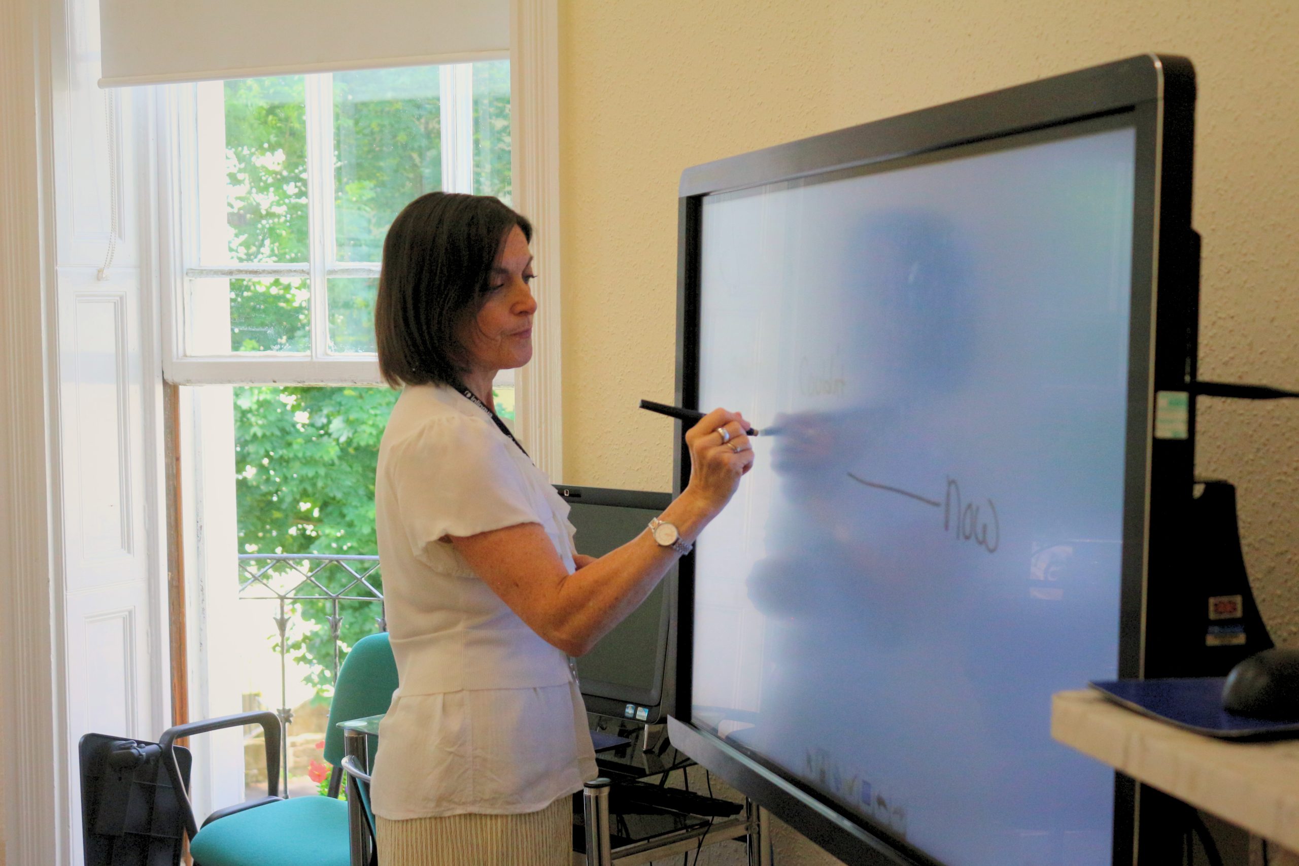 An experienced English teacher leading a class at inlingua Cheltenham