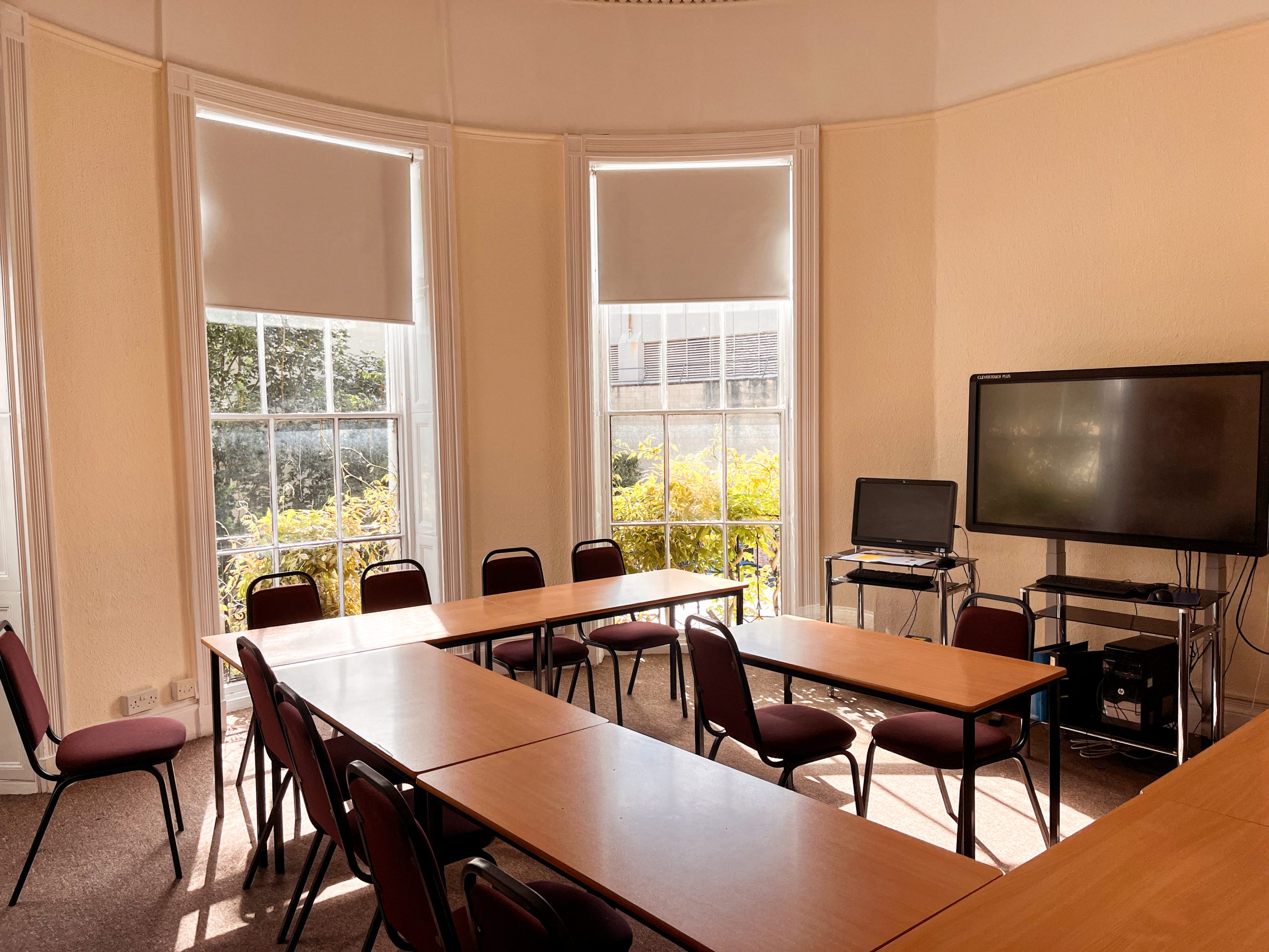 A small group of adult students working around a table with their teacher