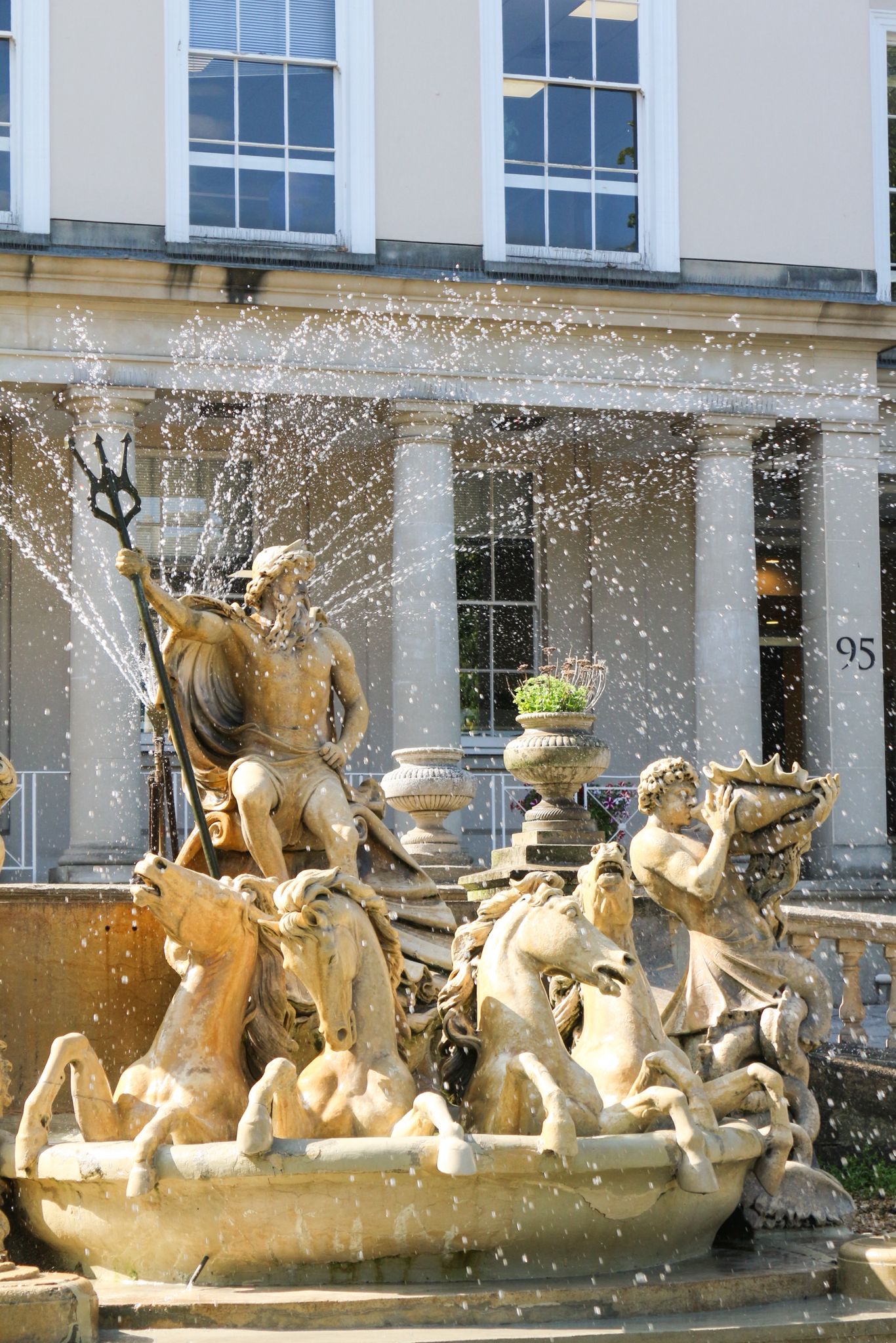 The Neptune Fountain on Cheltenham's Promenade, with water and classical statuary