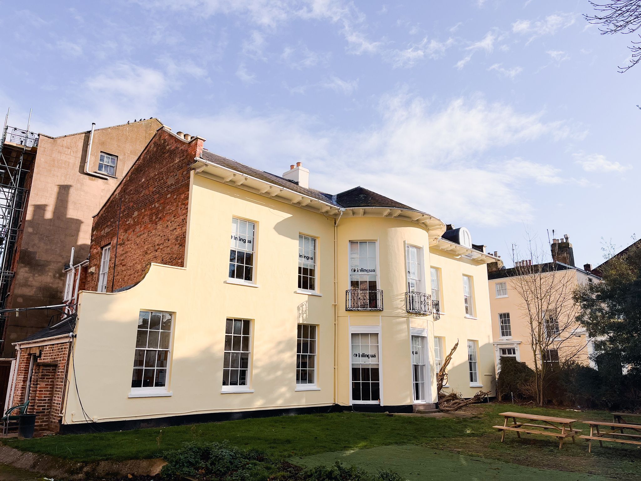 The Regency facade of inlingua Cheltenham at Rodney Lodge, 9 Rodney Road, with wrought-iron balconies and window boxes